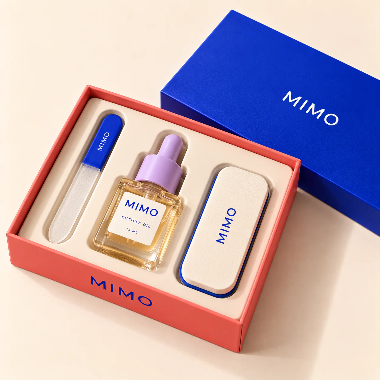 ชุดดูแลเล็บ MIMO Essential กล่องสีปะการังเปิดอยู่ ภายในมีตะไบเล็บแก้ว ออยล์บำรุงจมูกเล็บ และตลับ MIMO วางคู่กับฝากล่องสีน้ำเงิน